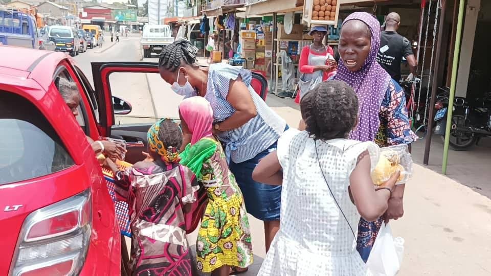 Volunteers distributing support items to families outdoors